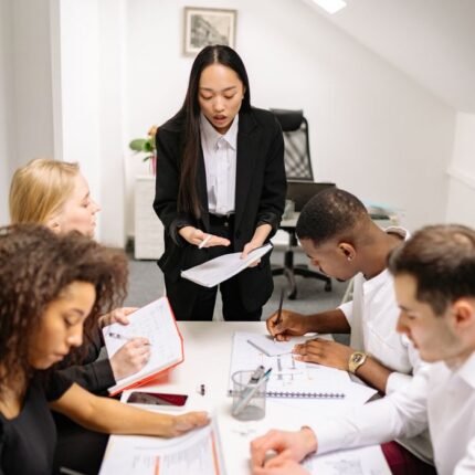 Colleagues engaged in a collaborative meeting in a modern office setting, discussing business plans.